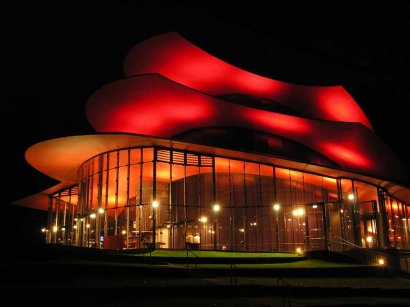 das Glasfoyer des neuen Theaters nach Sonnenuntergang